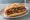 Choripán de Costanera: an illustration of pork, sausage and chimichurri on baguette.