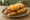 Cincinnati Chili Dog: an illustration of pork, cheddar cheese, onion and mustard on hot dog bun.