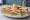 Club Sandwich Parisien: an illustration of chicken, bacon, lettuce, tomato and more on white bread.