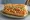 Crawfish Po' Boy: an illustration of lettuce, tomato, mayonnaise and pickle on baguette.