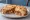 Croque-Bolognaise: an illustration of beef, ham, gruyère, béchamel and more on white bread.