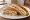 Cuban Sandwich (Miami): an illustration of ham, pork, swiss cheese, pickle and more on cuban bread.