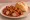 Currywurst ohne Darm: an illustration of ketchup and curry powder on kaiser roll.