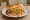 Dabeli with Extra Sev: an illustration of potato and chutney on bread.