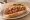 Dogo Sonorense: an illustration of pork, bacon, beans, tomato and more on telera roll.