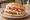 Dominican Chimi Burger: an illustration of beef, cabbage, tomato, onion and more.