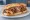 Döner Karışık: an illustration of beef, chicken, tomato, onion and more on bread.