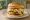 Double-Double: an illustration of beef, american cheese, lettuce, tomato and more on burger bun.