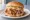 Eastern NC BBQ Sandwich: an illustration of pork, coleslaw, vinegar and pepper on burger bun.