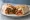 Fajita Burrito: an illustration of beef, chicken, pepper, onion and more on tortilla.