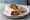 Falafel b'Saj (فلافل بالصاج): an illustration of chickpeas, tahini, parsley, tomato and more.