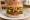 Falafel Burger: an illustration of chickpeas, tahini, lettuce, tomato and more on burger bun.