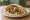 Falafel HaKosem: an illustration of chickpeas, tahini, tomato, cucumber and more on pita.