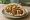 Falafel Sandwich (American): an illustration of chickpeas, tahini, lettuce, tomato and more on pita.
