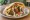 Falafel with Chips (פלאפל עם צ'יפס): an illustration of chickpeas, potato, tahini, tomato and more on pita.
