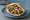 Falafel with Tahini (פלאפל עם טחינה): an illustration of chickpeas, tahini, tomato, cucumber and more on pita.