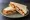 Fish Finger Sandwich: an illustration of fish, butter, tartar sauce and ketchup on white bread.