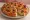 Focaccia Barese: an illustration of tomato, olives and olive oil.