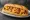 Frogmore Stew Sandwich: an illustration of shrimp, sausage and corn on hoagie roll.