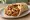 Garides se Pita (Γαρίδες): an illustration of shrimp, tomato, onion, lemon and more on pita.