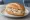 Geflügelsalat Brötchen: an illustration of chicken, mayonnaise, onion and pickle on bread.