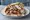 Greek-German Gyros: an illustration of pork, tzatziki, tomato, onion and more on pita.