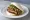 Guà Bāo (刈包): an illustration of pork belly, cilantro and maggi seasoning sauce.