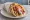 Gyros (Γύρος): an illustration of pork, chicken, tzatziki, tomato and more on pita.