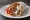 Gyros Hirino (Γύρος Χοιρινό): an illustration of pork, tomato, onion, tzatziki and more on pita.