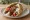 Gyros - Island Style: an illustration of lamb, tomato, onion and tzatziki on pita.