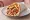Gyros Kotopoulo Apo Ola: an illustration of chicken, tomato, onion, tzatziki and more on pita.