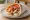 Gyros Kotopoulo me Tzatziki: an illustration of chicken, tomato, onion and tzatziki on pita.