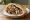 Haifa Style: an illustration of lamb, tahini, tomato, onion and more on pita.