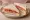 Ham and Tomato: an illustration of ham, tomato and butter on white bread.