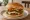Hamburger Türk Usulü: an illustration of beef, sucuk, lettuce, tomato and more on burger bun.