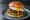Hamburger z Jajkiem: an illustration of beef, egg, lettuce, tomato and more on burger bun.