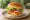Hamburger z Kurczaka: an illustration of chicken, lettuce, tomato, onion and more on burger bun.