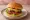 Hamburger z Serem: an illustration of beef, cheese, lettuce, tomato and more on burger bun.
