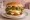 Hamburguesa Completa: an illustration of beef, ham, cheese, egg and more on burger bun.