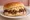 Hawaiian Plate Lunch Sandwich: an illustration of beef, rice and teriyaki sauce on burger bun.