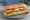 Hellim Ekmek: an illustration of halloumi, tomato and lettuce on bread.