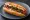 Hot Dog con Chile: an illustration of sausage on hot dog bun.