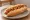 Hot Dog z Prażoną Cebulką: an illustration of sausage, onion, ketchup and mustard.