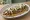 Huarache con Suadero: an illustration of beans, salsa, cheese, onion and more.