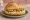 Hummus Brötchen: an illustration of hummus, chickpeas, tahini, lemon and more on kaiser roll.