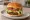 Impossible/Beyond Burger: an illustration of lettuce, tomato, onion, pickle and more on burger bun.