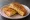 Isaac Toast — Honey Garlic Toast: an illustration of butter, garlic, honey and cheese on white bread.