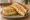 Isaac Toast — Scrambled Ham & Cheese: an illustration of ham, egg, cheese and butter on white bread.