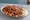 İskender Bir Buçuk: an illustration of lamb, beef, marinara, butter and more on pita.