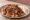İskender Kuzu: an illustration of lamb, marinara, butter and yogurt on pita.